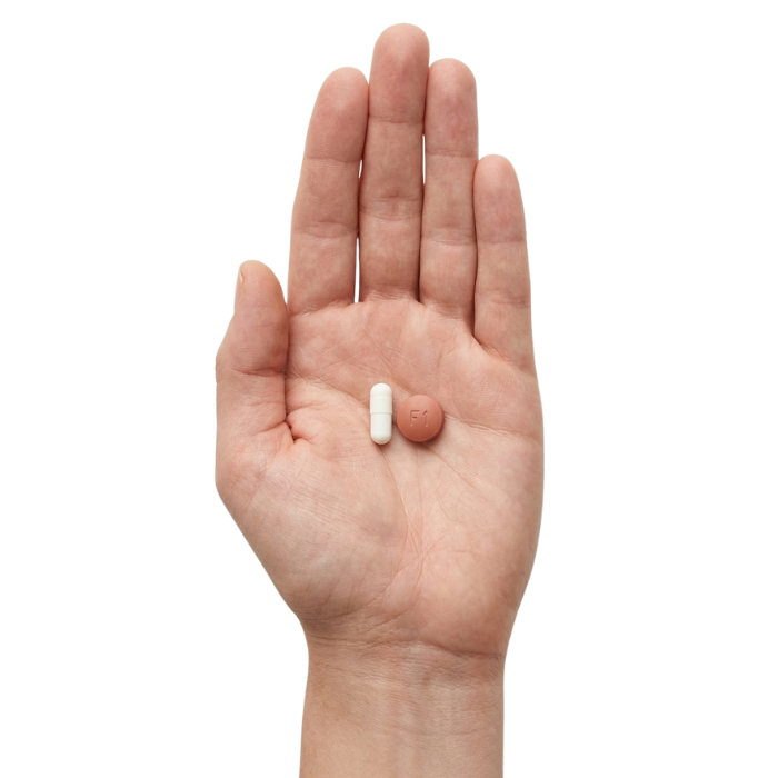 hand holding minoxidil and finasteride pills